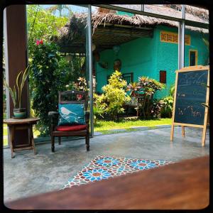 a chair and a chalkboard in front of a house at The Happy Bird B&B in Hoi An