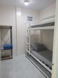 Cette chambre comprend 2 lits superposés et un miroir. dans l'établissement Jens Samal Vacation Rental - Centrally Located - Fully Furnished 2br WIFI, à Babak