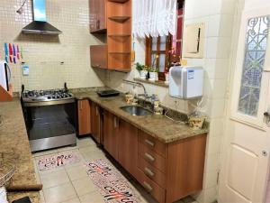 a kitchen with a sink and a stove at Casa Aurora Luz do Amanhecer in Rio de Janeiro