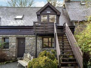 a stone house with a wooden staircase leading up to it at Kite 2 - Uk6547 in Llanfihangel-Bryn-Pabuan