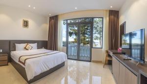 a bedroom with a bed and a desk with a television at Rung La Kim Resort in Da Lat