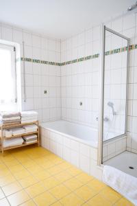 a white bathroom with a tub and a shower at Ferienhaus Marina in Weil am Rhein +56 photos
