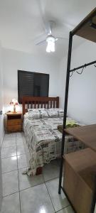 a bedroom with a bed and a table with a fan at Cantinho do Boris l in Ubatuba