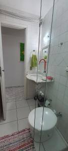 a bathroom with a white toilet and a sink at Cantinho do Boris l in Ubatuba
