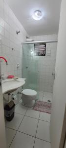 a bathroom with a shower and a toilet and a sink at Cantinho do Boris l in Ubatuba