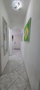 a hallway with white walls and a tile floor at Cantinho do Boris l in Ubatuba