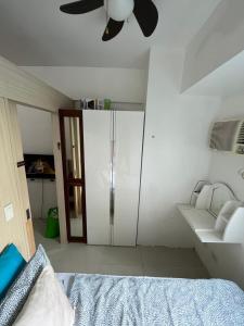een slaapkamer met een bed en een plafondventilator bij JC Condo, Jazz Bel-air Makati, POOL VIEW in Manilla