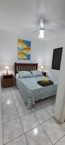 a bedroom with a bed and a flat screen tv at Cantinho do Boris l in Ubatuba