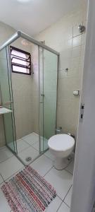 uma casa de banho com uma cabina de duche em vidro e um WC. em Cantinho do Boris l em Ubatuba