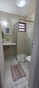 a bathroom with a shower and a sink and a toilet at Cantinho do Boris l in Ubatuba