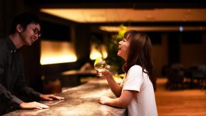 TUNE STAY KYOTO في كيوتو: a man and a young girl holding a glass of wine