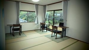 een kamer met een tafel, stoelen en ramen bij Isumi seishinso - Vacation STAY 84726v in Isumi