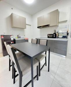 a kitchen with a table and chairs in a room at TheSun #BayanLepas#QueensbayMall#PISA#USM in Bayan Lepas