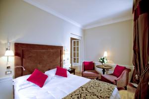 a bedroom with a large bed with red pillows at Hotel Clitunno in Spoleto