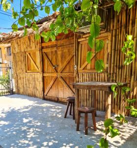 een houten schuur met een bank en een houten deur bij Hospedaje Combi dream bird in Guanacaste