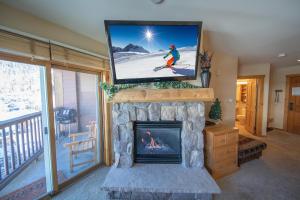 uma sala de estar com lareira e uma televisão por cima em Buffalo Lodge 8381 em Keystone