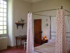 a bedroom with a canopy bed with pink curtains at Chateau de la Bastide in Goudargues