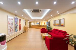 a waiting room with red couches in a hospital at Home Inn Dalian North Railway Station in Dalian