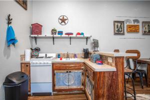 a kitchen with a stove and a sink and a counter at Lonesome Dove Bandera Cabin in Bandera