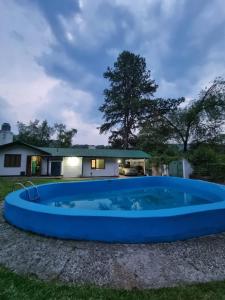 una gran piscina azul frente a una casa en El Mirador Los Nogales in 