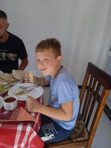 un joven sentado en una mesa comiendo comida en SILVER RAIL en Galle