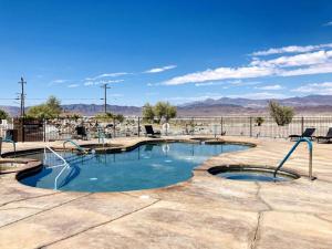 a swimming pool in the middle of a desert with mountains at Death Valley Hot Springs 2 Bedroom in Tecopa