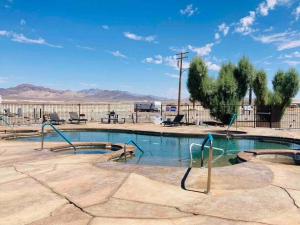 una piscina en un parque con montañas al fondo en Death Valley Hot Springs 2 Bedroom, en Tecopa