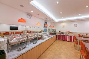 a fast food restaurant with a long counter with tables and chairs at Home Inn Dalian North Railway Station in Dalian