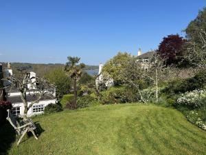 a grassy hill with a house in the background at Thornwell Cottage - Heart of the village, amazing gardens, glorious views and brimming with character in Dittisham