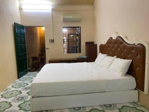 a bedroom with a large bed with a wooden headboard at T30 Hanoi Homestay, near Lotte Tay Ho, 25minutes to the airport in Hanoi