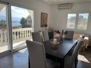 a dining room with a table and chairs and a balcony at Country house by the Sea 200m & Sea View with garden in Agioi Theodoroi