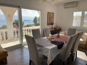 a dining room table and chairs with a view of the ocean at Country house by the Sea 200m & Sea View with garden in Agioi Theodoroi