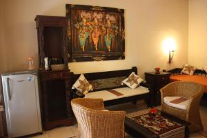 a living room with a couch and a refrigerator at Rambutan Hotel in Lovina