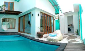 a house with a swimming pool next to a house at Villa Giyor in Nusa Lembongan