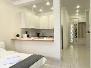 uma cozinha com armários brancos e uma cama num quarto em Апартаменты в элитном ЖК em Pavlodar