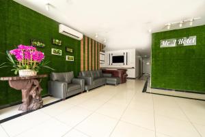 um átrio com cadeiras e uma parede verde em MRJ Hotel Wakaf Che Yeh 1 em Kota Bharu