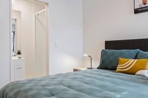een slaapkamer met een bed met blauwe en gele kussens bij 1 Bedroom City Base with Free Car Park in Christchurch +9 foto's