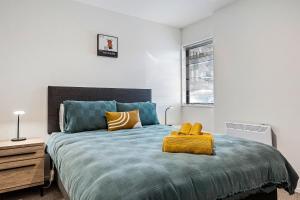 a bedroom with a large bed with a yellow blanket at 1 Bedroom City Base with Free Car Park in Christchurch