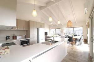 eine Küche mit einer weißen Arbeitsplatte und ein Wohnzimmer in der Unterkunft Beach Haven in Merimbula