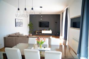 a living room with a table and white chairs at Kosante - luxury apartment - 150 m2 with fitness room in Imotski