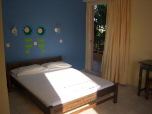 uma cama num quarto com uma parede azul em Vamvini Hotel em Sarti