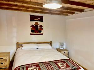 ein Schlafzimmer mit einem Bett und einem Wandgemälde in der Unterkunft Casa Museo - Naturaleza y Tradición in Otavalo