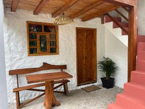 a wooden bench sitting in front of a house at Casa Museo - Naturaleza y Tradición in Otavalo