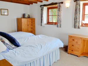 a bedroom with two beds and a wooden dresser at Mill Moor - B6064 in Pooley Bridge