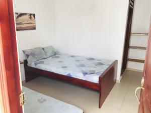 Hostería Altamar Tolú في تولو: غرفة نوم صغيرة مع سرير في غرفة