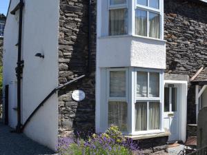a stone house with a clock on the side of it at The Nook in Ambleside