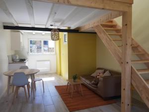 a living room with a loft with a couch and a table at La Petite Sommière in Besançon