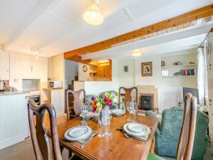 a dining room with a wooden table and chairs at Memory Cottage in Mevagissey