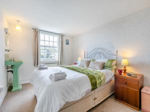 Un dormitorio con una cama grande y una ventana en Memory Cottage, en Mevagissey