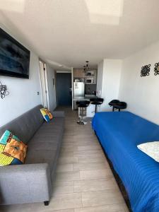 ein Wohnzimmer mit einem Sofa und einem Bett in der Unterkunft Maravilloso departamento en Nuevo Edificio Eco-Costas de ConCón-Reñaca en la mejor ubicación de Bosques de Montemar frente JUMBO con estacionamiento privado Full Amoblado- Wi-Fi-Cable- Smart TV en las 2 habitaciones, amplia terraza- bella vista al mar in Concón